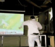 a man in white pants is dancing in front of a large screen .