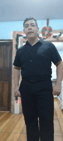 a man in a black shirt and black pants is standing in a room