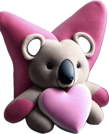 a stuffed koala bear with pink wings holding a pink heart