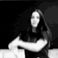 a black and white photo of a woman with long hair dancing .