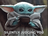 a baby yoda from star wars is holding a cup of coffee .