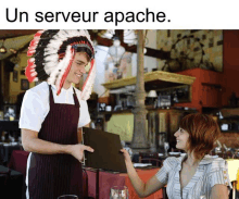 a man wearing a native american headdress is serving a menu to a woman