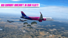 a wizzair airplane is flying in the sky with parachutes coming out of it