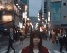 a woman in a red jacket stands in front of a busy street with a sign that says ' coca cola ' on it