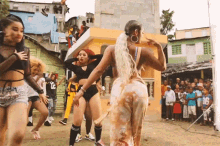 a group of women are dancing in front of a crowd with one wearing the number 16 on her shirt