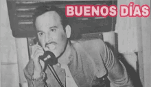 a black and white photo of a man talking on a phone with the words buenos dias below him