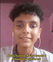 a young man with curly hair is wearing headphones and smiling with a caption that says aaunu huncha