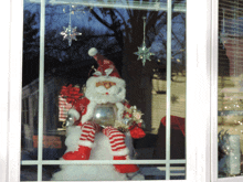 a santa claus figurine is sitting on a snowman