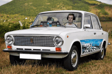 a white car with ample style written on the side is parked in a grassy field