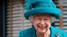 queen elizabeth wearing a blue hat and pearls