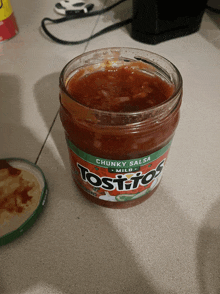 a jar of tostitos chunky salsa is sitting on a counter