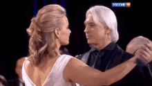 a man and a woman are dancing in front of a screen that says " russia hd "