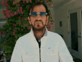a man wearing sunglasses and a peace sign on his neck