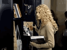 a woman with curly hair is standing in front of a locker with a picture of a butterfly on it