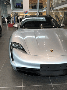 a silver porsche is parked in a car dealership