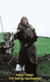 a man in a fur coat is standing in a field and asking for help