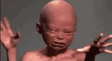 a close up of a baby 's face with its hands outstretched and crying .