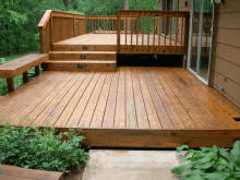 a wooden deck with stairs and a bench on it