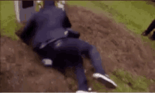 a man is laying on his back in the dirt on a hill .