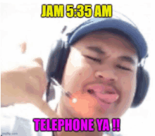 a man wearing headphones is talking on a cell phone with a caption that reads jam 5:35 am telephone ya !!