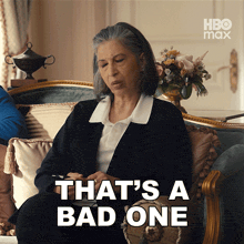 a woman is sitting on a couch with the words that 's a bad one on the bottom