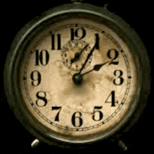 an old alarm clock shows that it is almost eleven o'clock