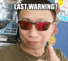 a man wearing red sunglasses is giving a thumbs up with the words last warning written above him