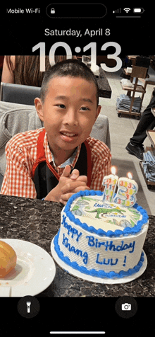 a young boy sitting in front of a birthday cake