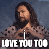 a man with a beard is making a heart shape with his hands .