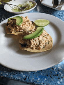 a plate of food with avocado and lime wedges