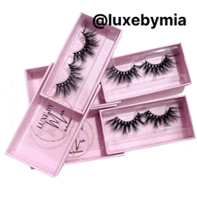 a stack of pink boxes filled with false eyelashes from luxebymia