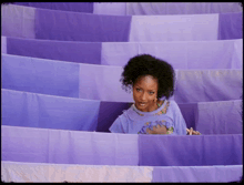 a woman in a purple shirt with a turtle on it stands in a purple maze
