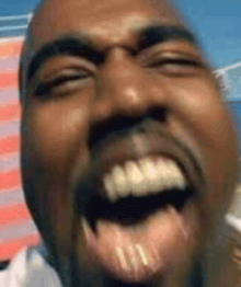 a close up of a man 's face laughing with his mouth open .