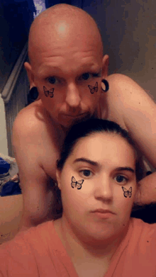 a man and woman with butterflies painted on their faces