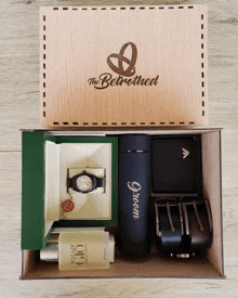 a wooden box contains a watch a bottle of acqua di gioia and a wallet