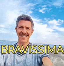 a man taking a selfie on the beach with the words bravissima above him