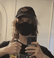 a man wearing a mask and a hat takes a selfie