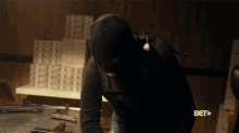 a man wearing a mask is standing in front of a bet logo