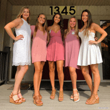 a group of women standing in front of a building with the number 1345