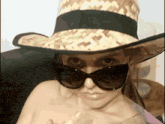 a woman wearing a straw hat and sunglasses