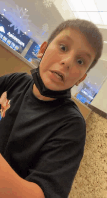 a young boy wearing a black mask is making a funny face in front of an angry birds restaurant