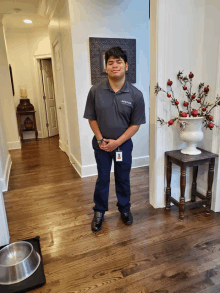 a man standing in a hallway wearing a gray shirt that says adaptive