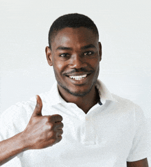 a man wearing a white shirt is giving a thumbs up