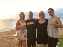 a man in a dewalt shirt poses with his family on the beach