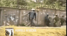 a group of people are standing in front of a wall with the words humble african written on the bottom