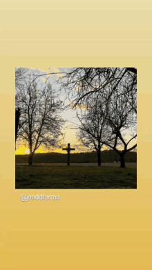 a picture of a cross in a field with the words @janddfarms below it