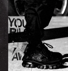 a black and white photo of a person 's feet with a sign that says you rule