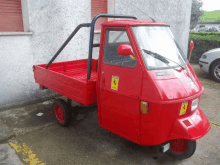 a small red vehicle with the word aprilia on the front