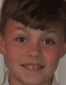 a close up of a young boy 's face with no teeth .