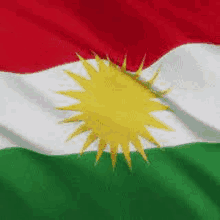 a red , white , and green kurdish flag with a yellow sun on it .